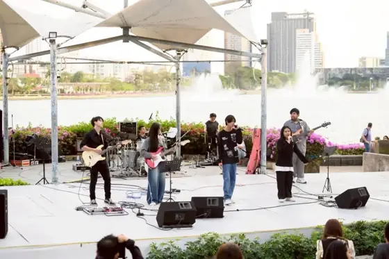 นักเรียนเล่นดนตรีเป็นวงบนเวทีกลางแจ้ง